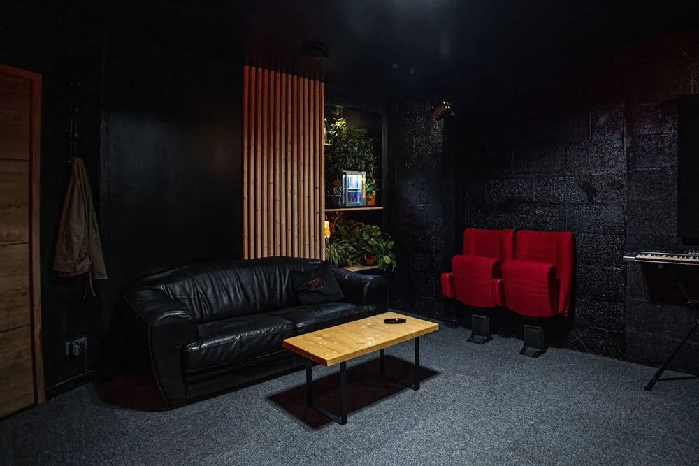 Le salon : canapé en cuir, table basse et fauteuils de cinéma rouges